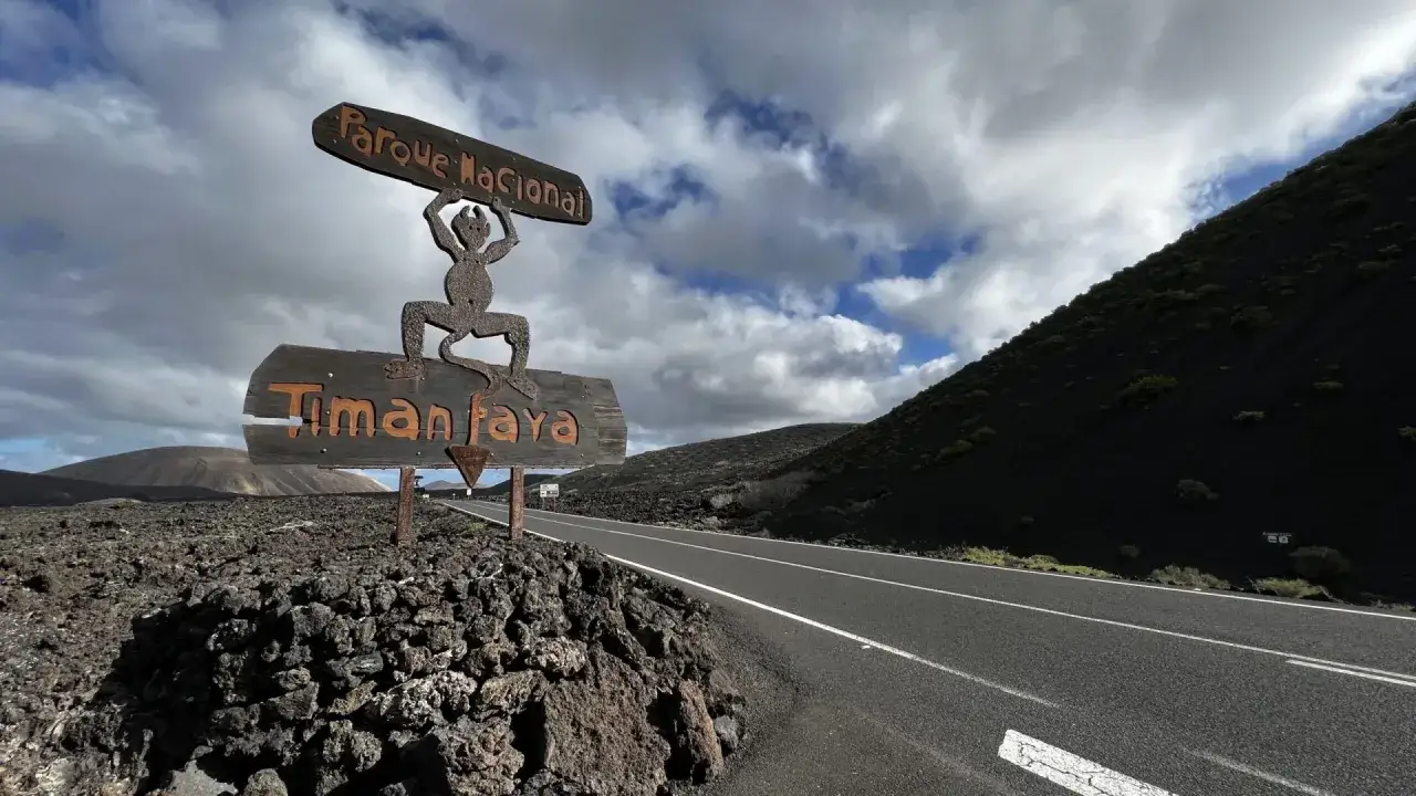 Cartel de Parque Nacional Timanfaya, ideal para tu plan de Lanzarote en 4 d&iacute;as. Paisaje volc&aacute;nico y cielo nublado.