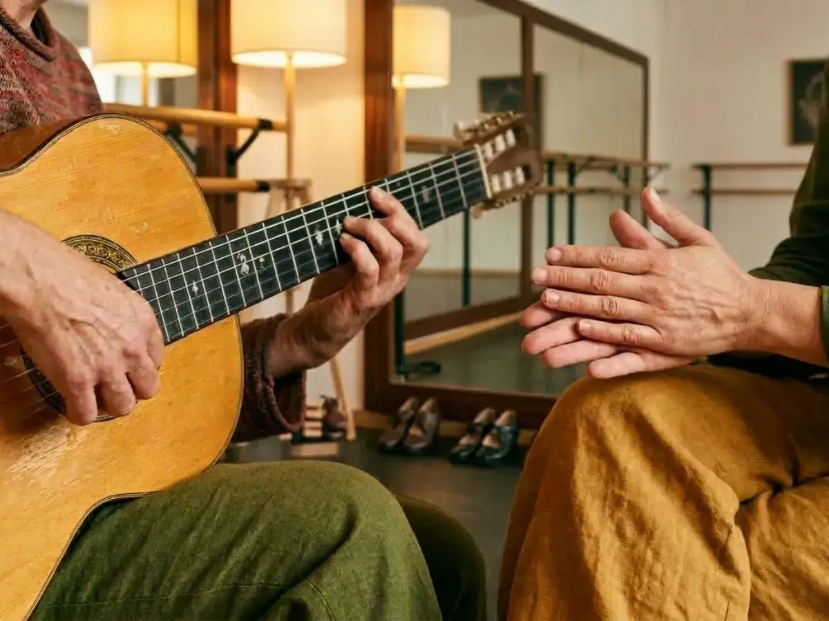 Manos que crean m&uacute;sica flamenca, una guitarra y palmas que acompa&ntilde;an el ritmo.