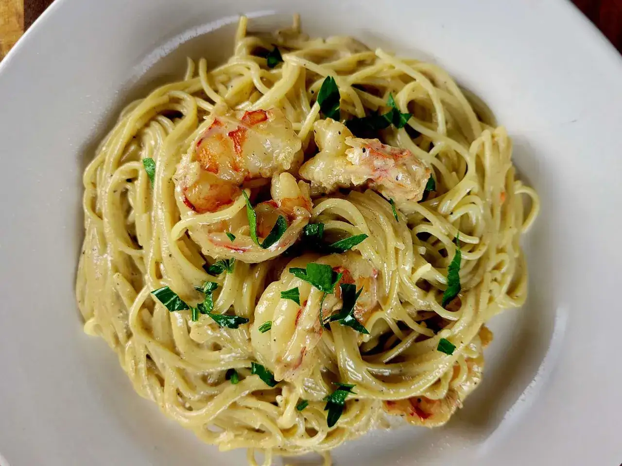 Spaghettis aux crevettes &agrave; l'ail et au persil, un plat cr&eacute;meux et savoureux, garni de persil frais.