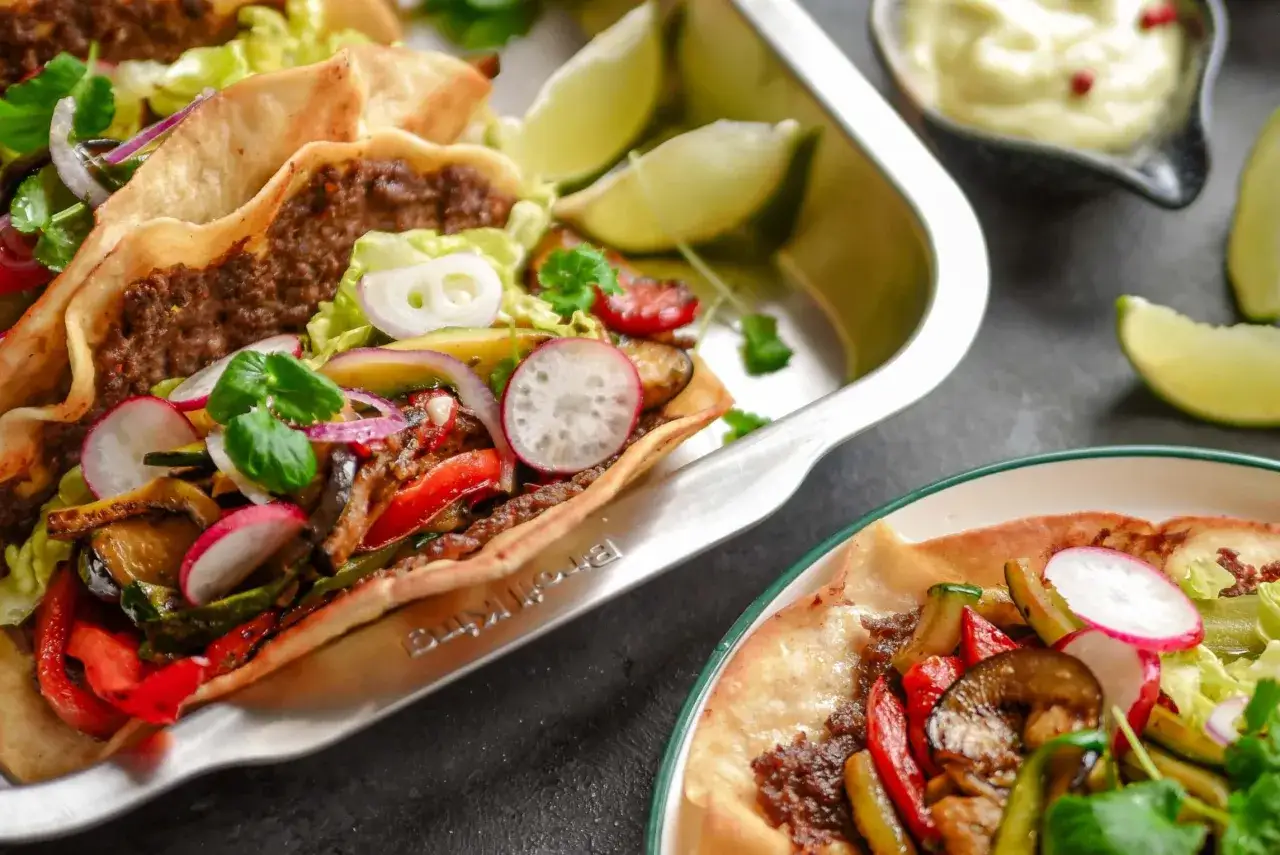 Pyszne tacos z mielonym mięsem i grillowanymi warzywami, idealne na co na grilla. Podane z limonką i sosem.
