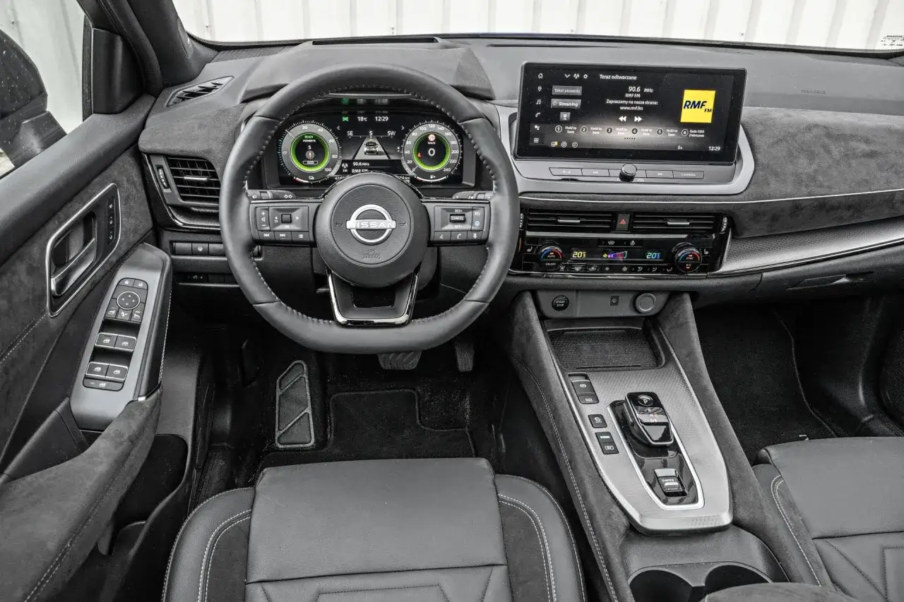 Wnętrze Nissana Qashqai, nowoczesny kokpit z ekranem multimedialnym i cyfrowymi zegarami. Sprawdź nissan qashqai cena!