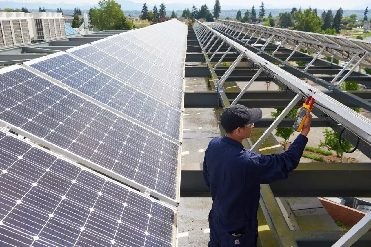 Tekniker m&auml;ter solpaneler p&aring; taket, kanske f&ouml;r att l&ouml;sa ett svea solar problem.