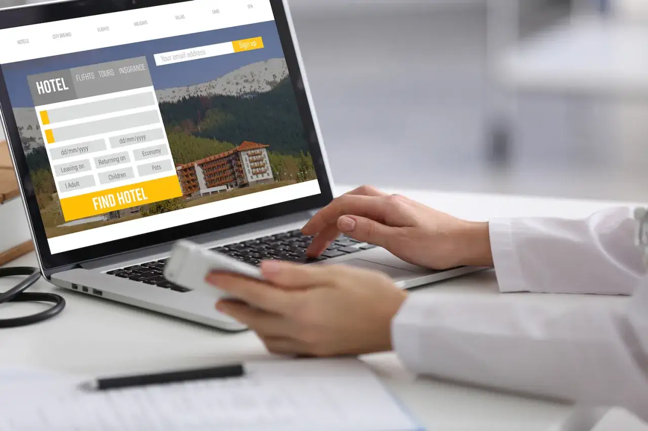 osoba por&oacute;wnująca oferty nocleg&oacute;w na laptopie