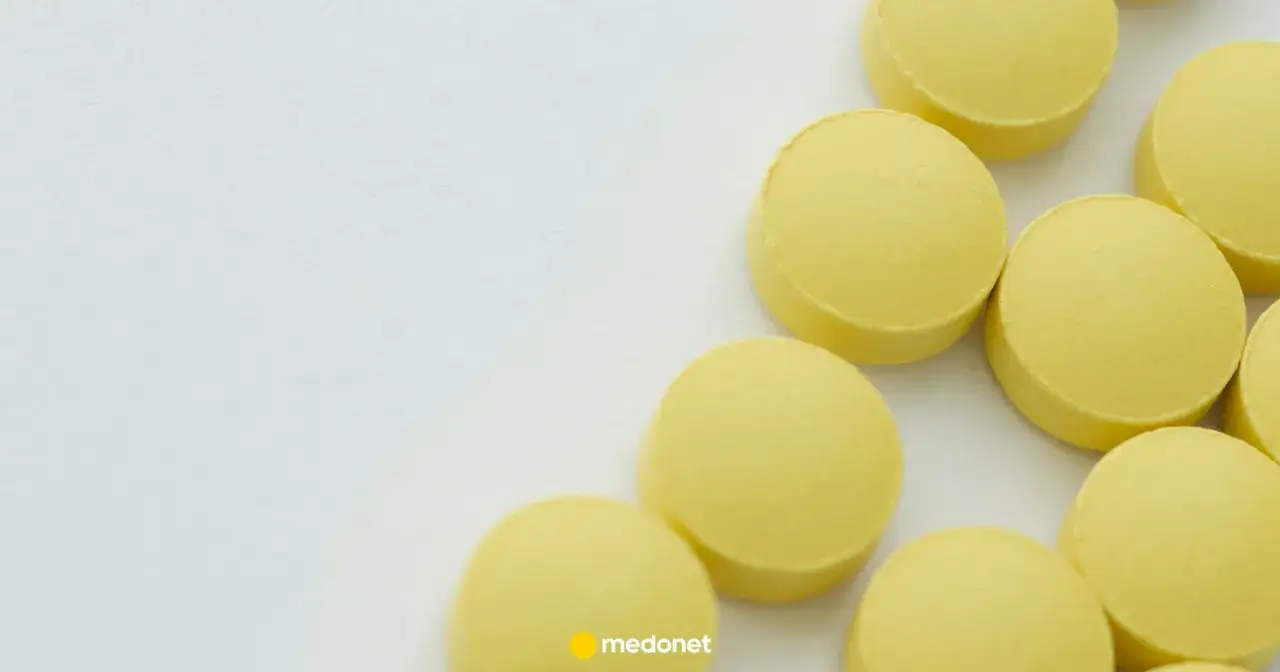 Kilka żółtych tabletek, każda o dawce aciprex 10 mg, leży na białym tle.