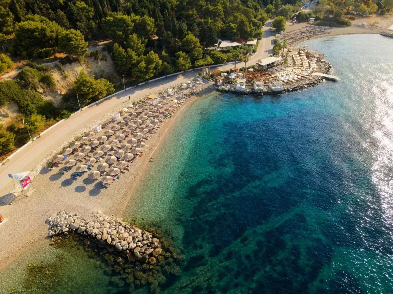 Widok z lotu ptaka na plażę z leżakami i parasolami, obok hotelu Radisson Blu Split.
