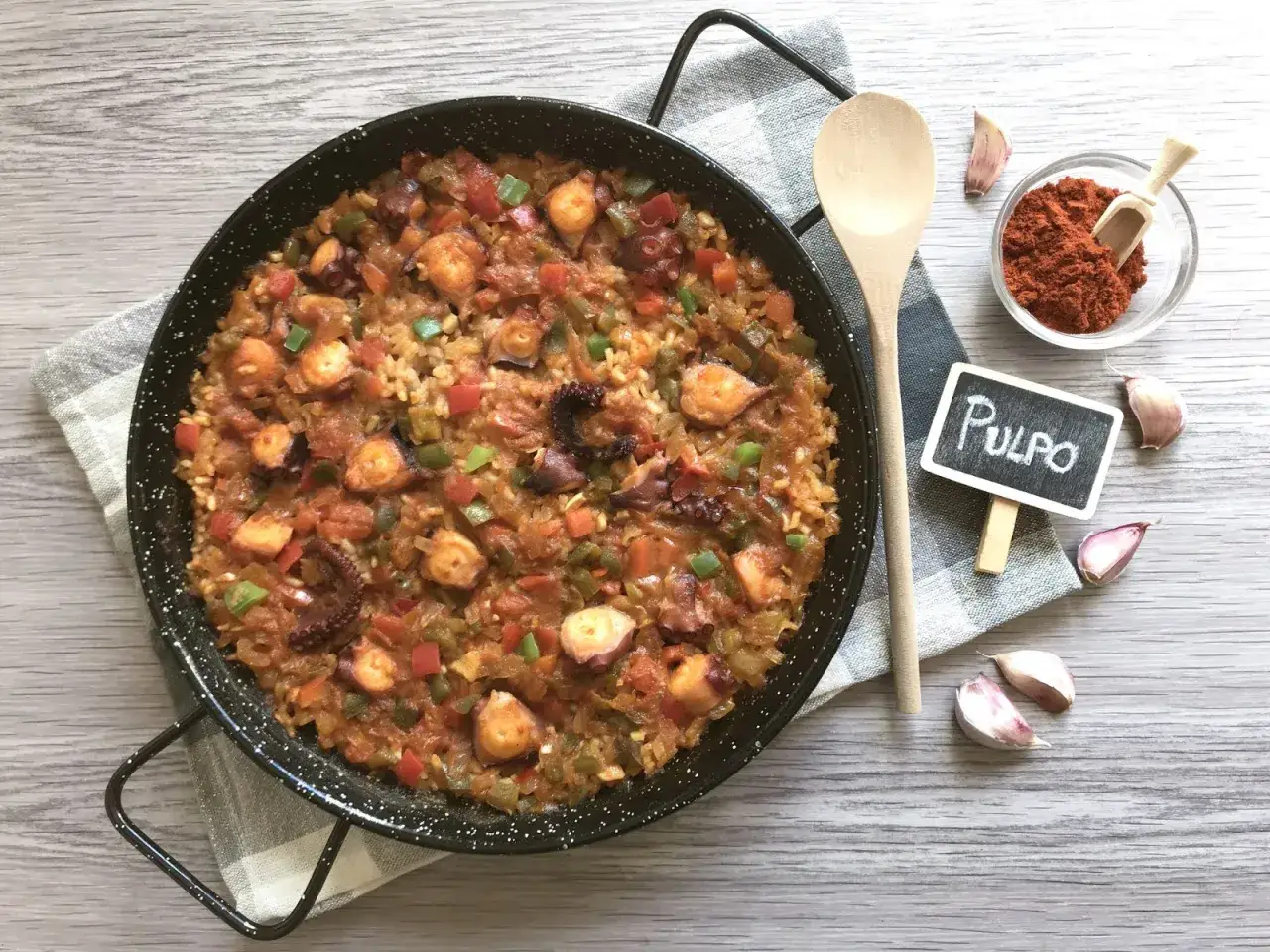 Paella de arroz con pulpo, pimientos y tomate, lista para disfrutar.