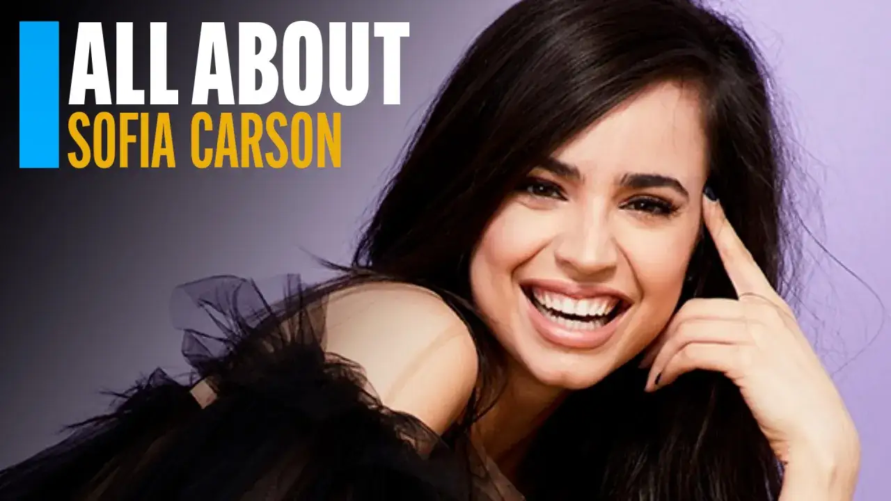 Uśmiechnięta Sofia Carson, gwiazda filmów, seriali i programów, w czarnej, tiulowej kreacji.