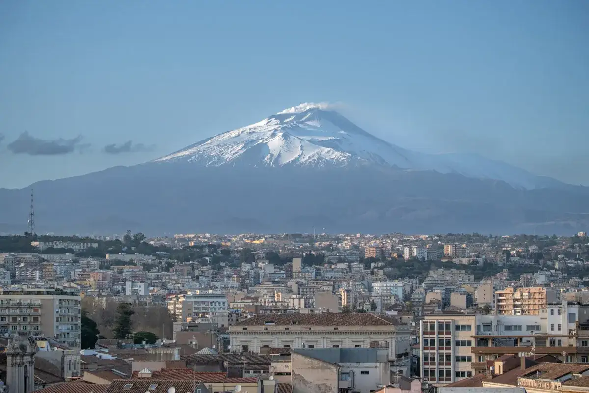 Widok na Katanię z ośnieżonym Etna w tle. Idealne miejsce, by zobaczyć majestat natury i urok sycylijskiego miasta.