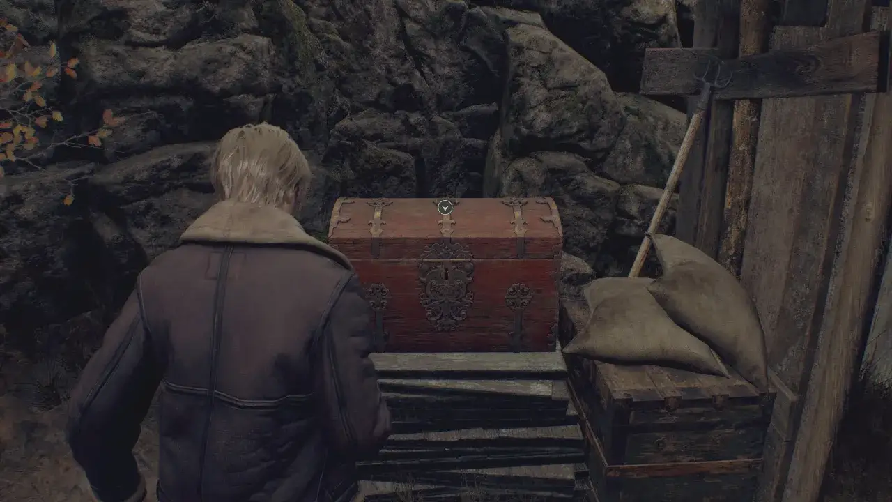 Leon zbliża się do skrzyni w jaskini. To ważny moment w Resident Evil 4 Remake poradnik.