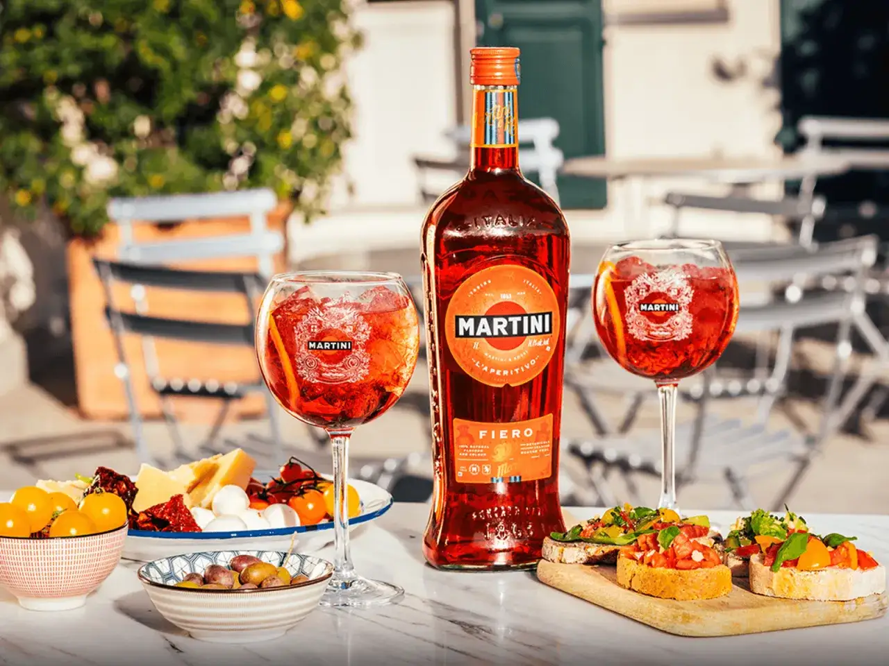 Martini Fiero z prosecco, podane z przekąskami na letnim tarasie.
