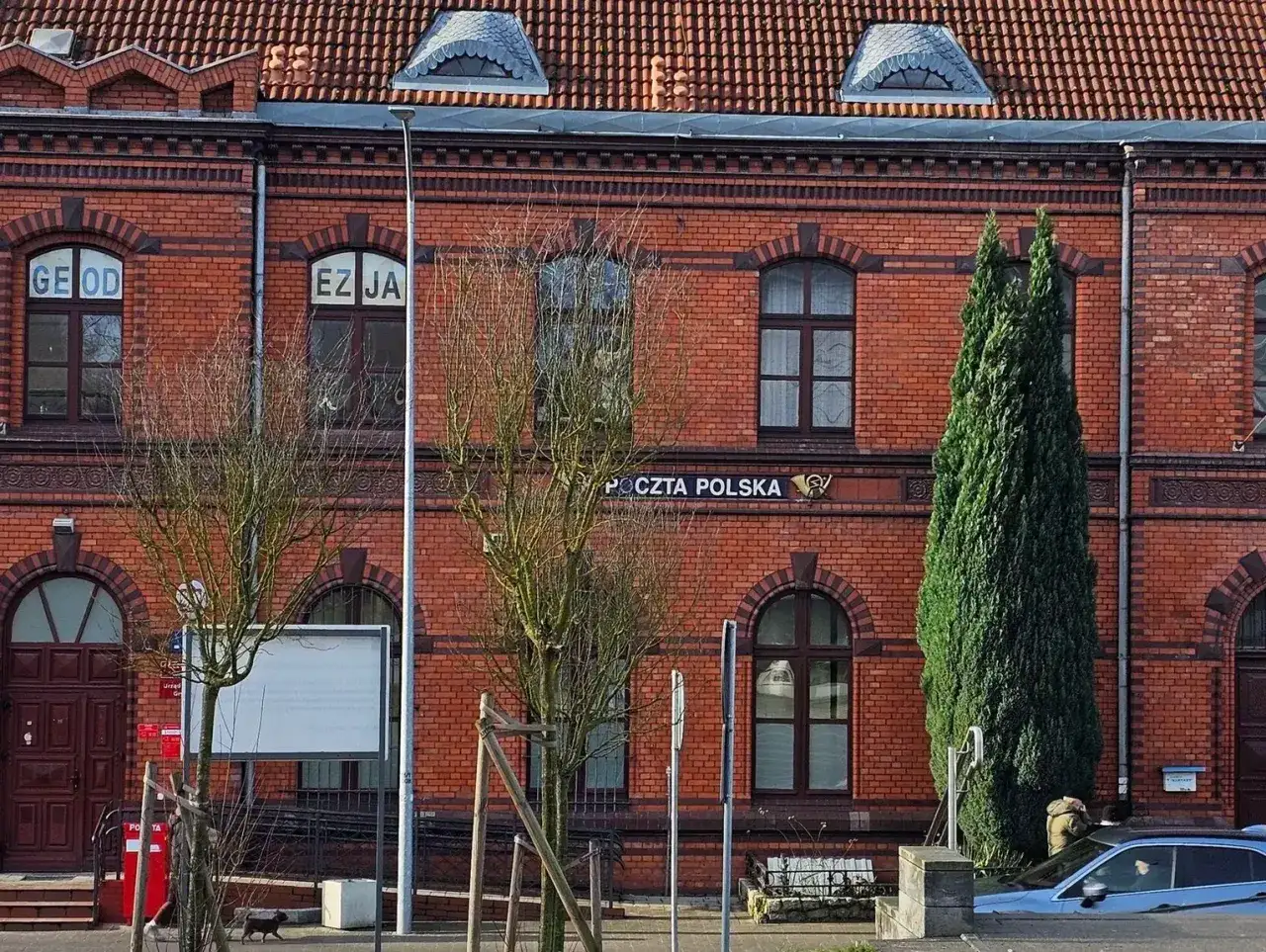 Czerwony budynek poczty z cegły, z napisem 