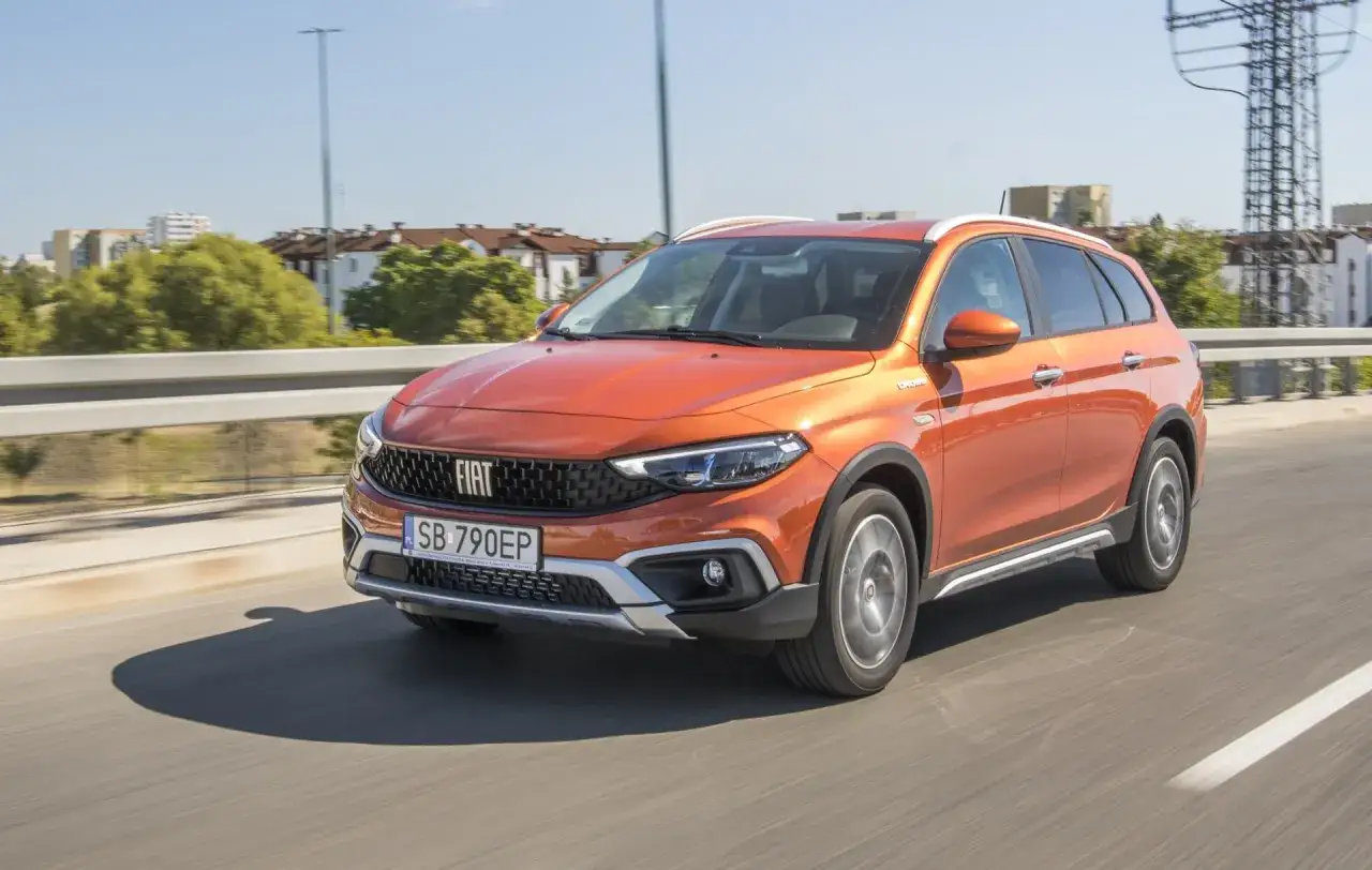Pomarańczowy Fiat Tipo Cross na drodze, idealny do rodzinnych podr&oacute;ży. Sprawdź atrakcyjne oferty fiat finansowanie.