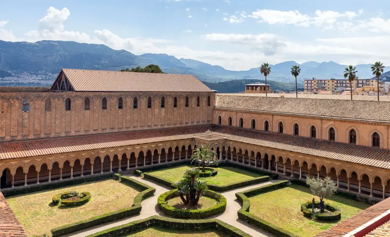 Monks religion: A serene cloister garden with manicured hedges and palm trees, surrounded by ancient monastic architecture.
