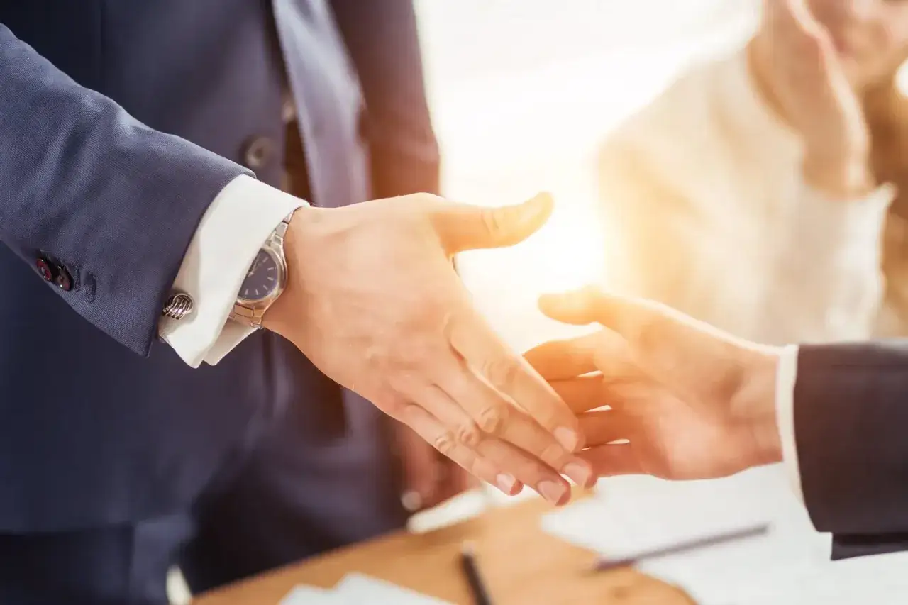 Uścisk dłoni między partnerami biznesowymi, symbolizujący wsp&oacute;łpracę z firmami odbierającymi odpady.