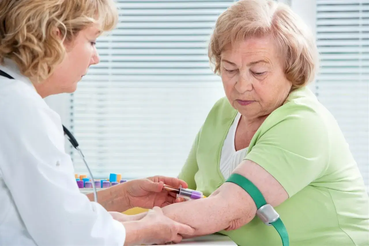 Lekarka pobiera krew od starszej kobiety. Badanie może pomóc w diagnostyce chorób autoimmunologicznych, np. anty CCP.