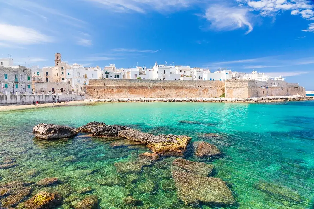 Un borgo bianco affacciato su un mare cristallino, una delle tante citt&agrave; da visitare in Puglia.