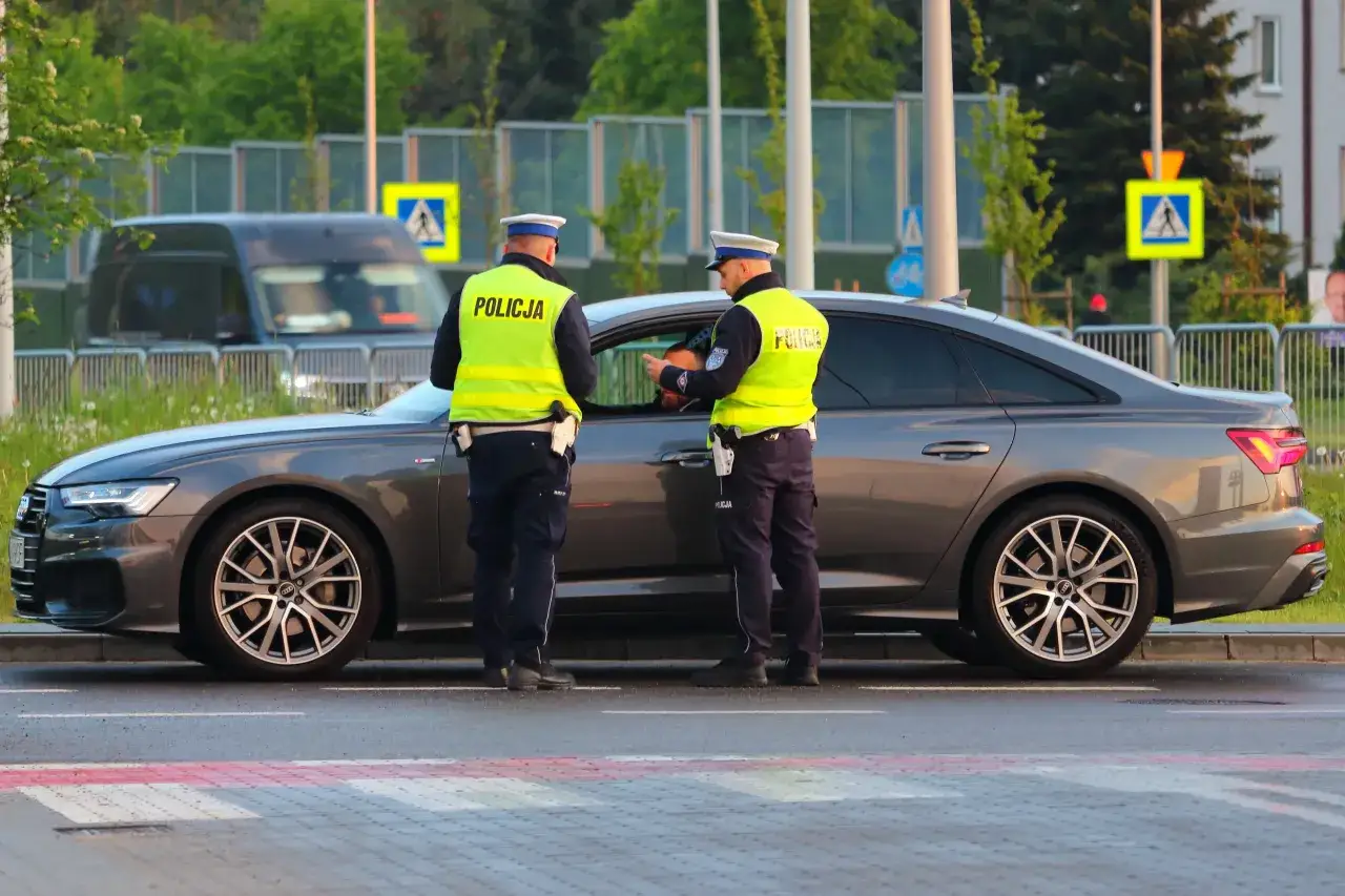 Policjanci kontrolują kierowcę stojącego na pasach. Czy trzeba mieć przy sobie prawo jazdy? To pytanie, które może zadać każdy kierowca podczas takiej kontroli.