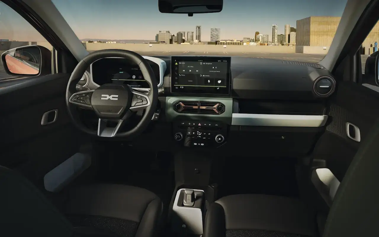 Wnętrze dacia elektryk z ekranem multimedialnym i nowoczesną kierownicą. Widok na miasto w tle.