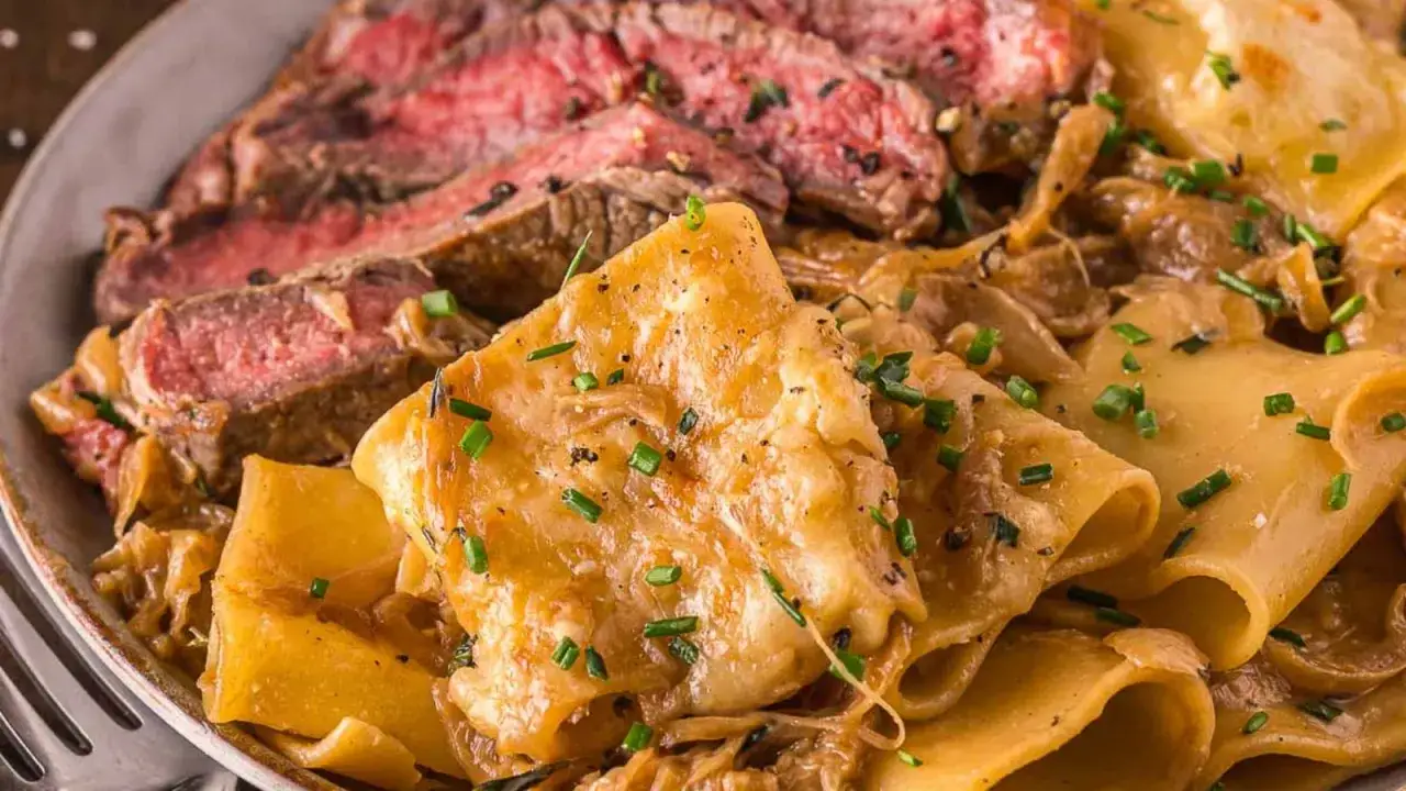 Tranches de bœuf saignant servies avec des pâtes larges nappées d'une sauce crémeuse et garnies de ciboulette. Un délice qui rappelle la sauce anglaise.