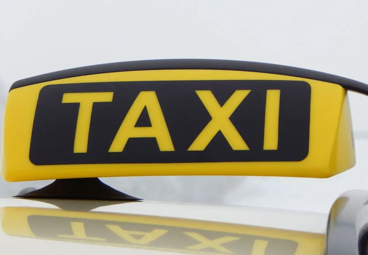 Gelbes TAXI-Schild auf einem Auto. Informiert &uuml;ber die taxi umbau kosten.