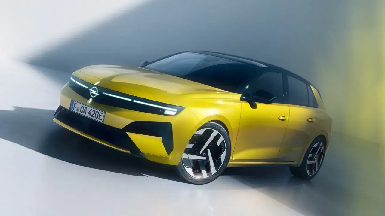 Żółty Opel Astra, jeden z najlepszych hatchbacków, prezentuje nowoczesny design z charakterystycznym oświetleniem LED.