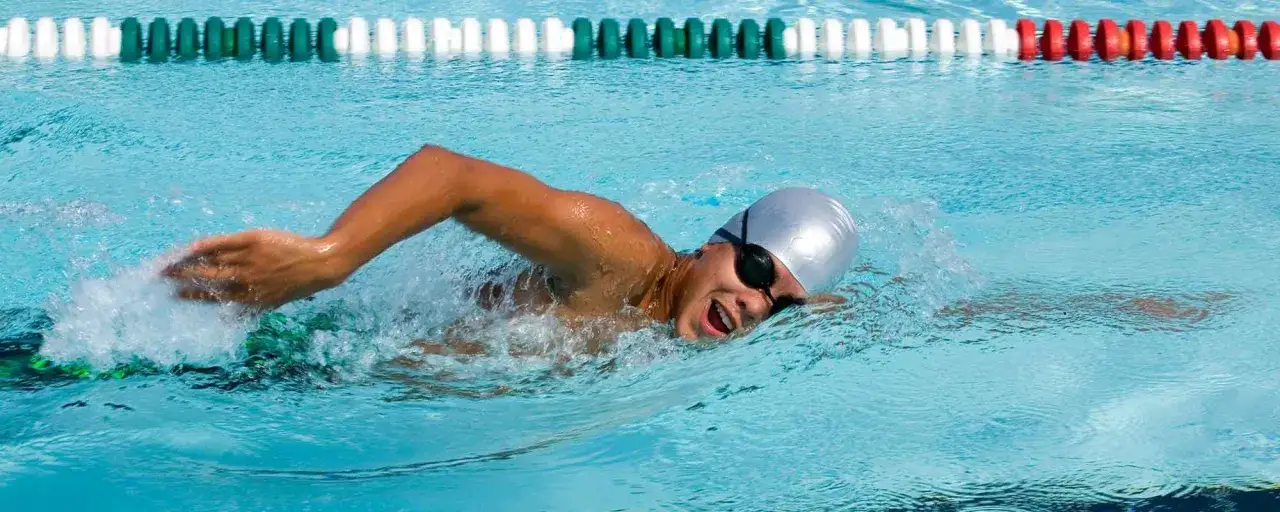 Swimmer powering through endurance swim workouts, focused and determined.
