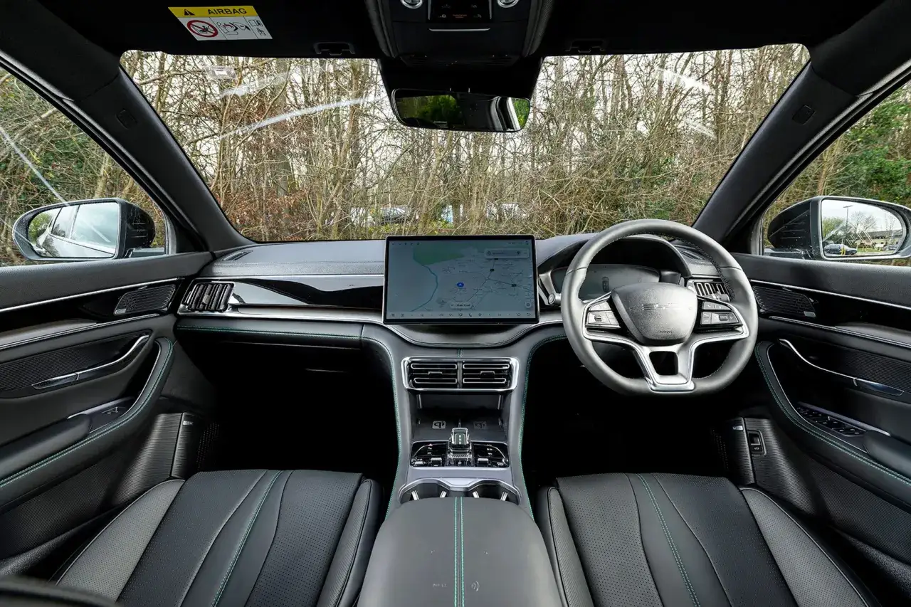 Vue de l'intérieur d'une BYD Seal, avec son grand écran tactile central, son volant moderne et ses sièges confortables.