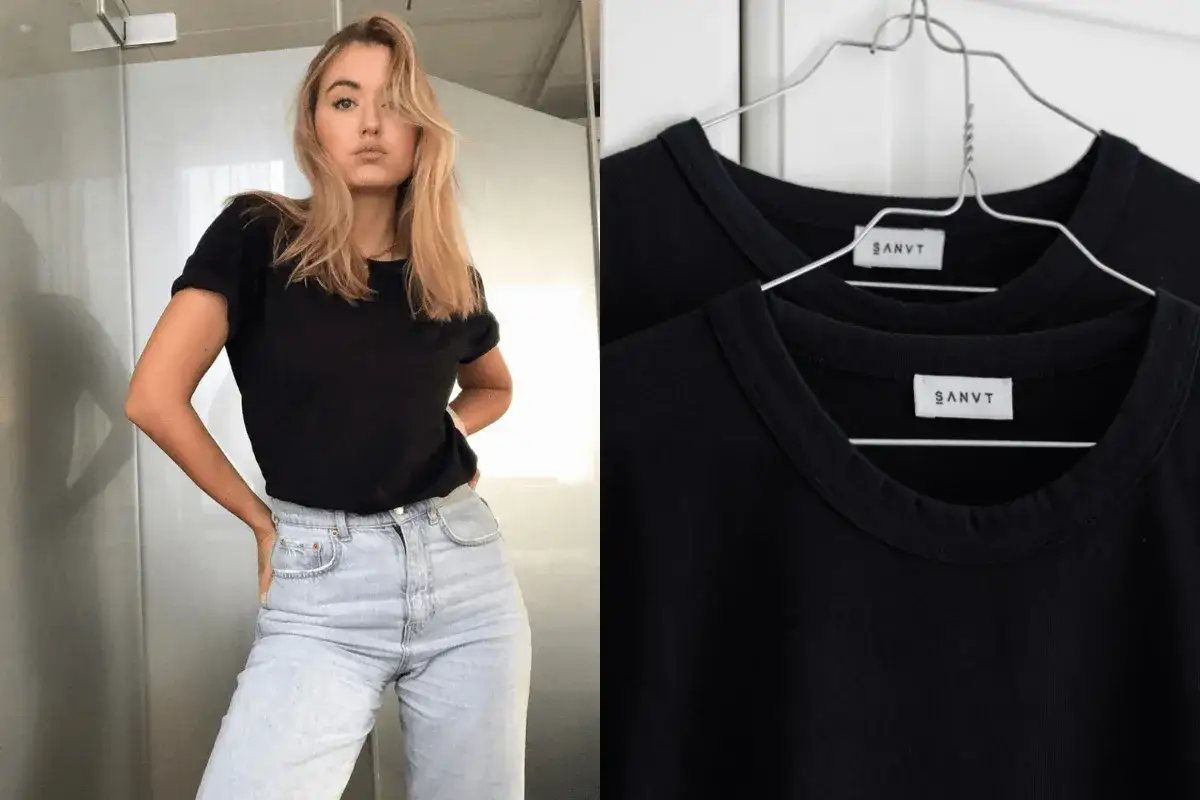 Une jeune femme porte une tenue avec t-shirt noir et jean clair. &Agrave; c&ocirc;t&eacute;, deux t-shirts noirs identiques sont suspendus.