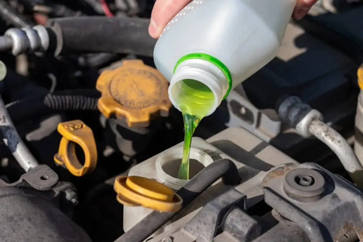 Vertiendo anticongelante etilenglicol en un motor de aluminio para protegerlo del fr&iacute;o.