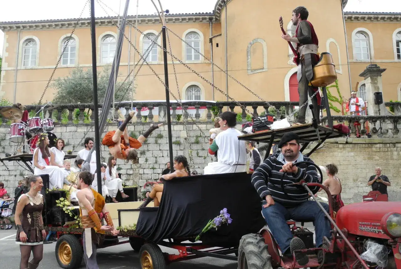 Un spectacle de rue animé lors d'un corso à Apt, avec des acrobates aériens, des musiciens et des costumes historiques.
