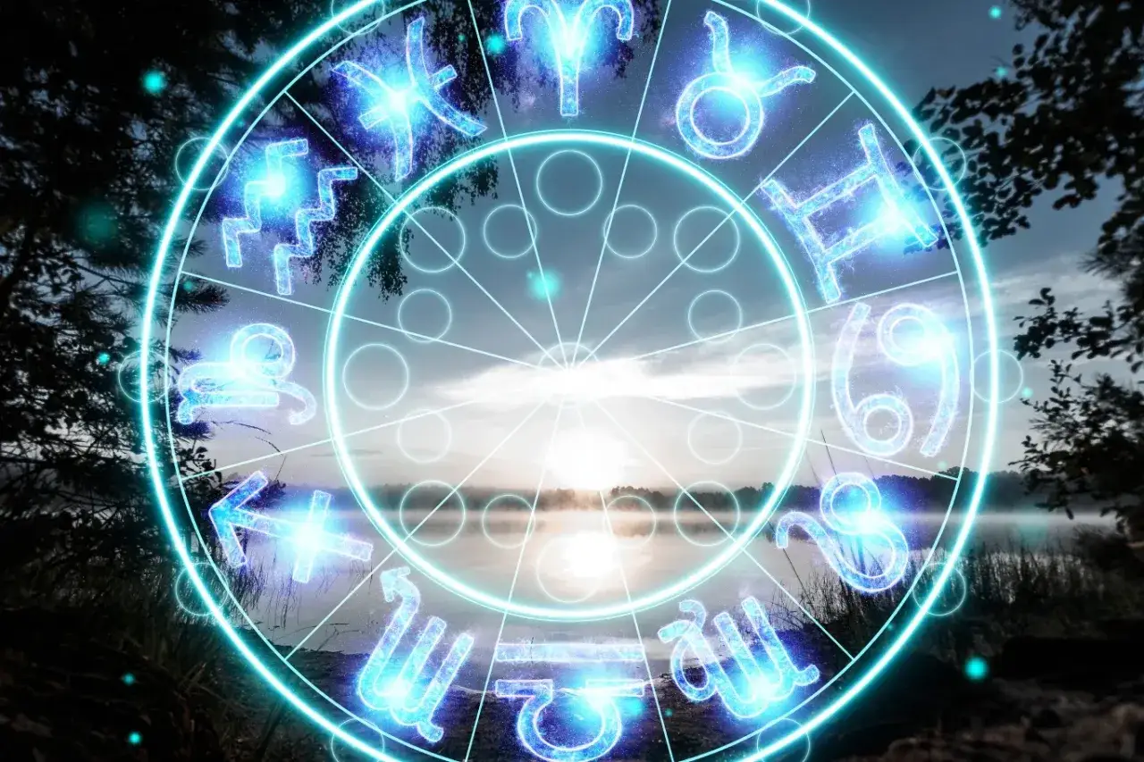 Jasny krąg z wodnymi znakami zodiaku nad mglistym jeziorem o wschodzie słońca.