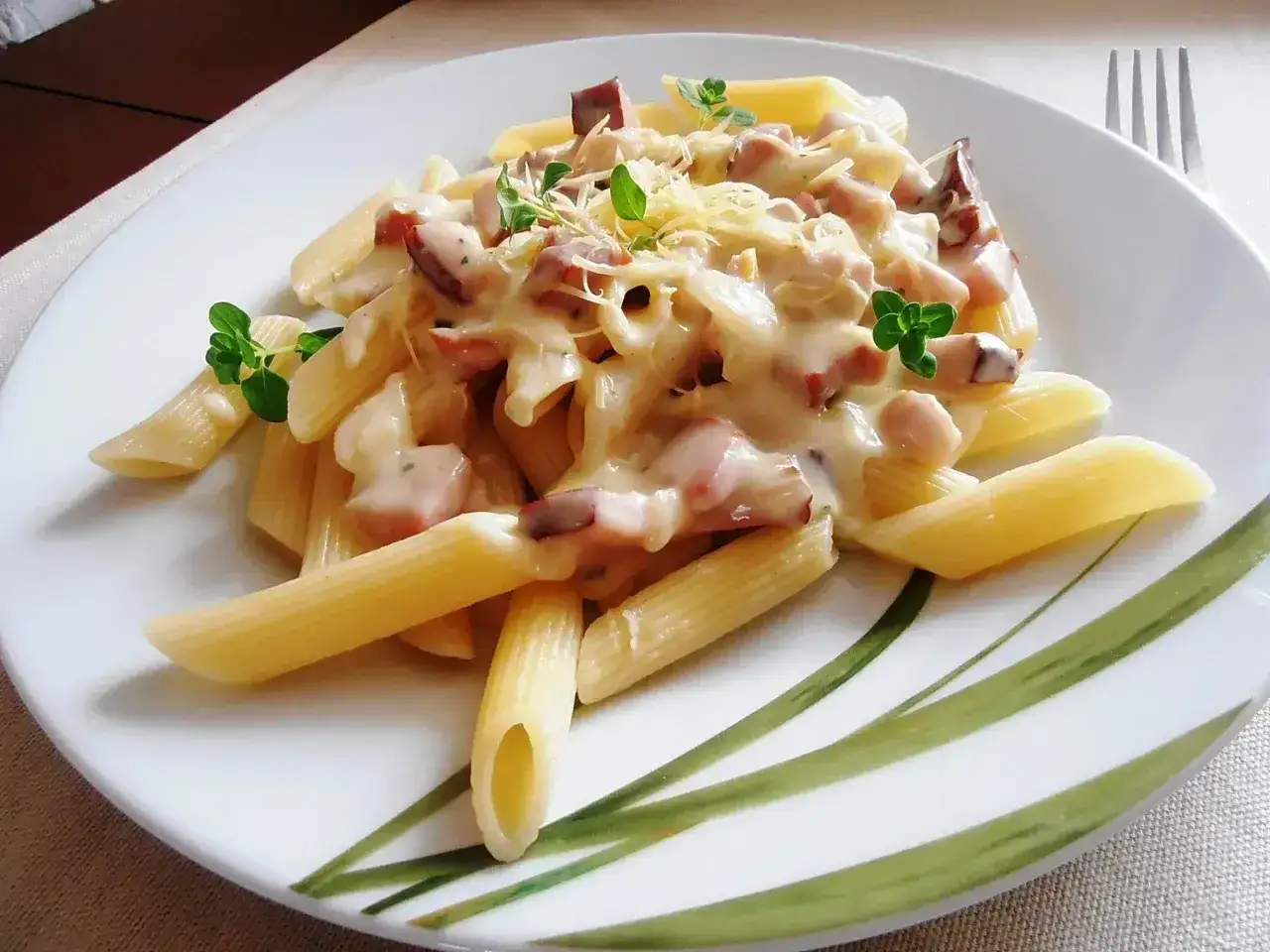 Penne rigate z kremowym sosem, boczkiem i ziołami. To pyszne danie, które pokazuje, co to jest penne.