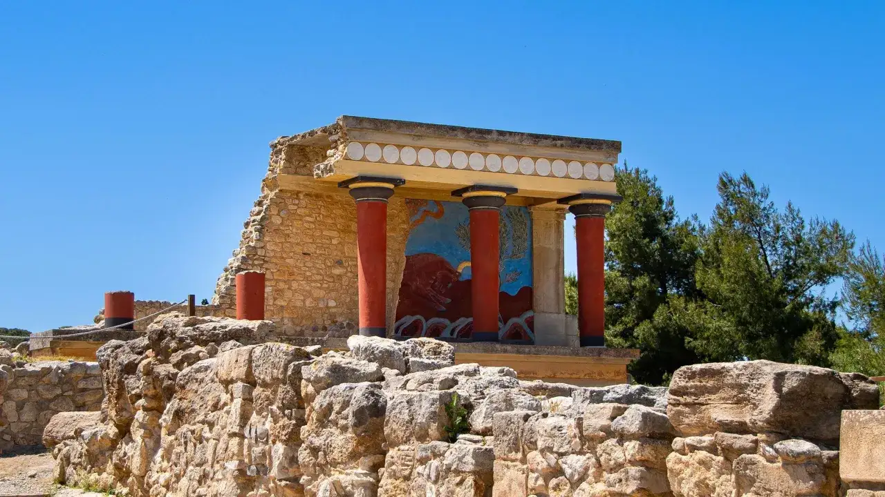 Ruines d'un monastère abandonné, avec des colonnes rouges et une fresque représentant un taureau.