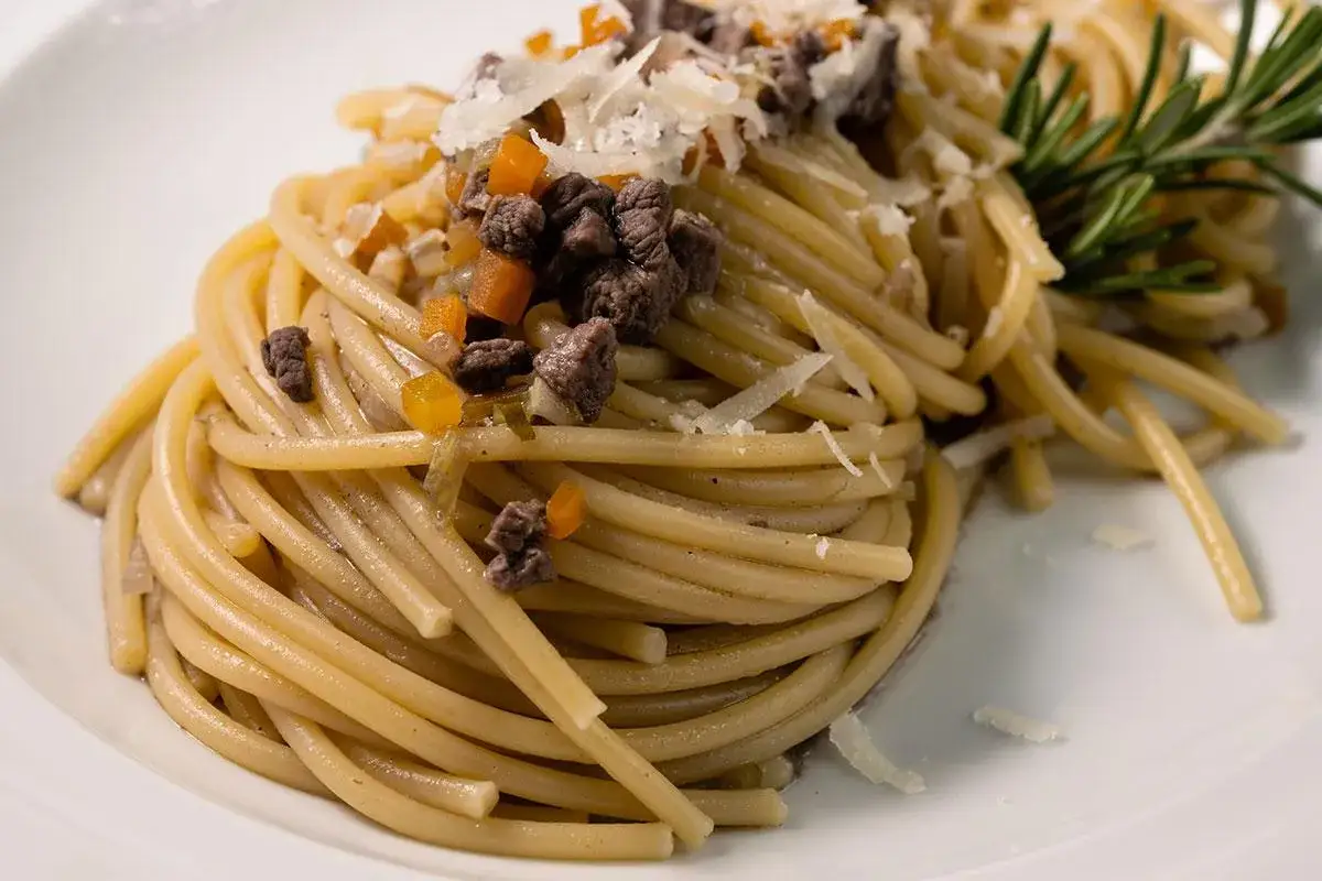Spaghetti al ragù di selvaggina, un sapore autentico dei ristoranti dei Colli Euganei. Guarnito con parmigiano e rosmarino.