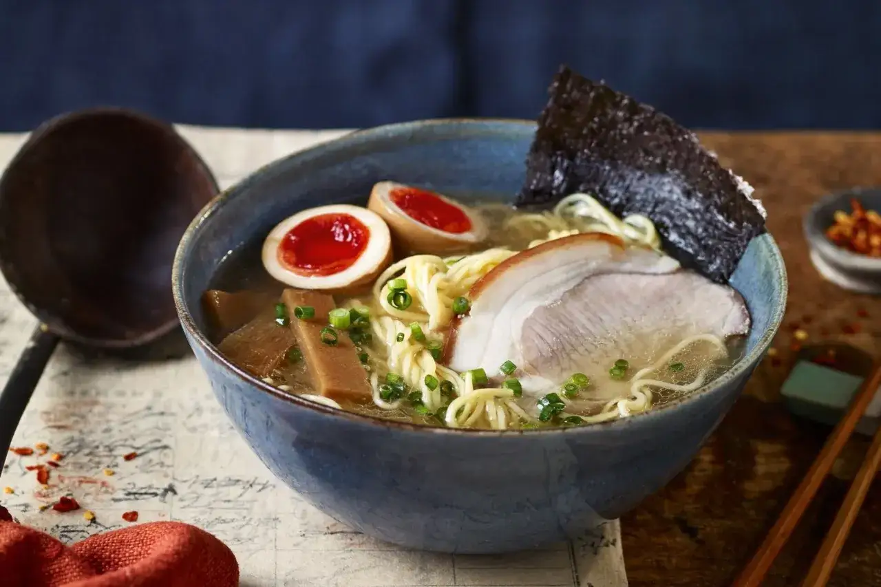 Miseczka aromatycznego ramen: makaron, jajko na pół, plastry mięsa, bambus i nori. Idealne danie, gdy zastanawiasz się, ramen co to.