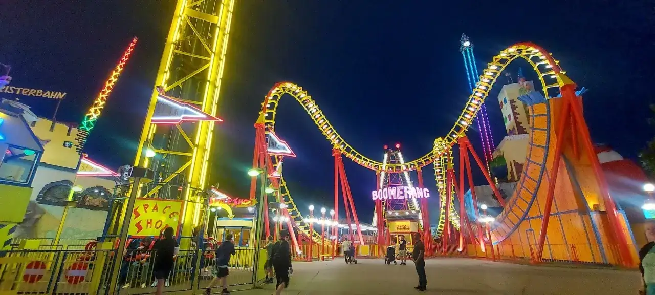 Wiedeński Prater nocą: kolejka Boomerang i wieża Space Shot. Sprawdź prater wiedeń cennik przed wizytą.
