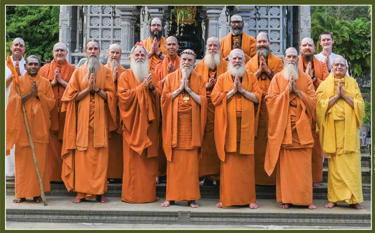 A group of men in orange robes stand with hands pressed together, a gesture of respect. This is what humility looks like.