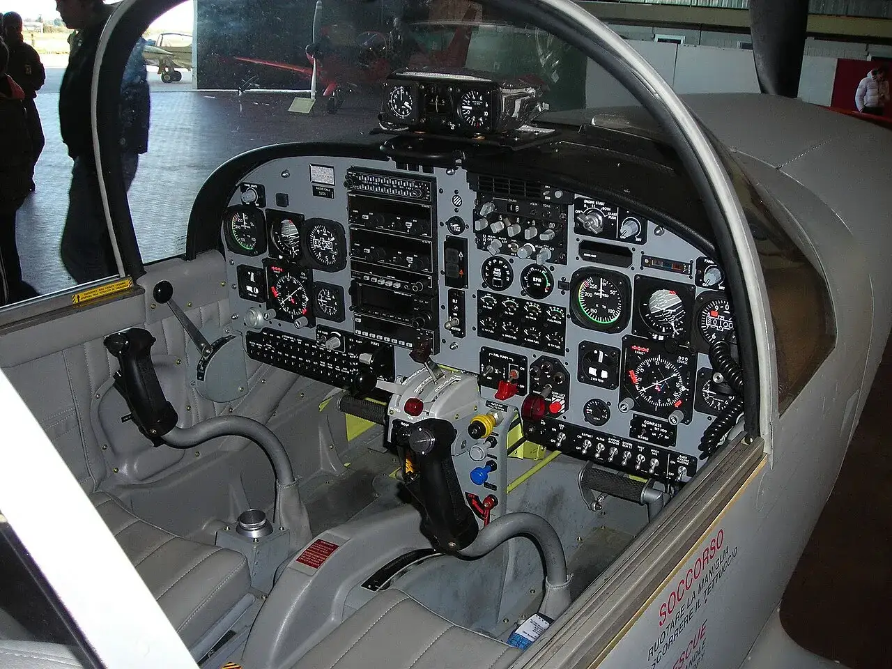Cockpit eines sf260 Flugzeugs mit vielen Instrumenten und Bedienelementen.