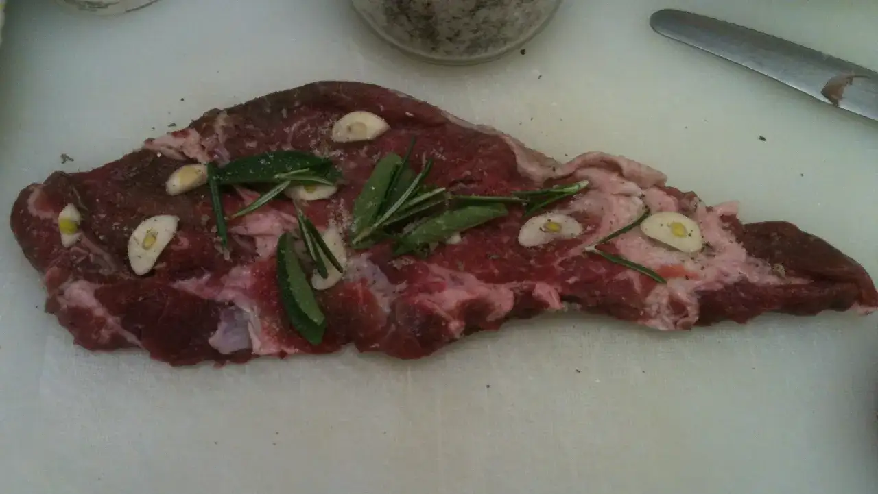 Scamerita al forno con aglio, rosmarino e salvia, pronta per essere cucinata.
