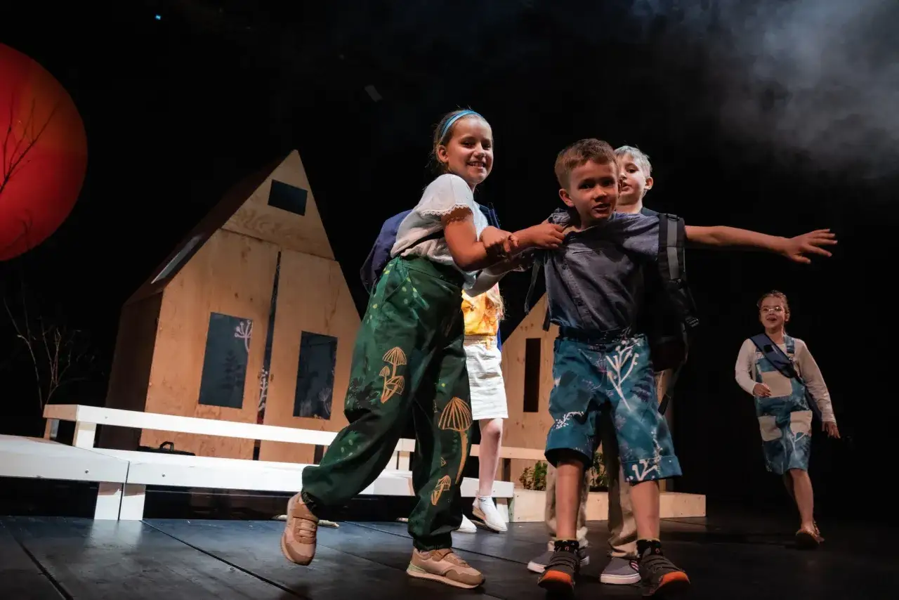Dzieci na scenie Teatru Małego w Tychach, wesoło bawią się podczas spektaklu.
