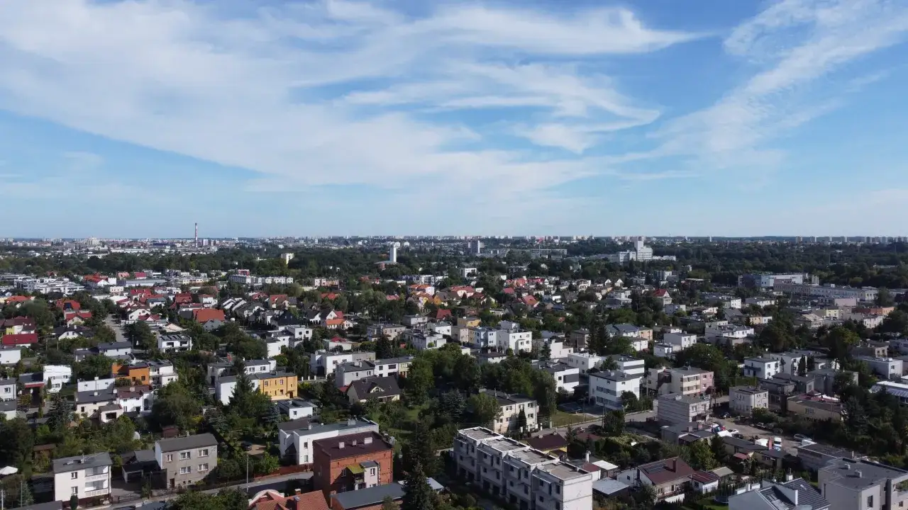 Widok z lotu ptaka na Bydgoszcz. Widać zabudowania mieszkalne, drzewa i niebo. Idealne miejsce do sprawdzenia rankingu biur nieruchomości Bydgoszcz.