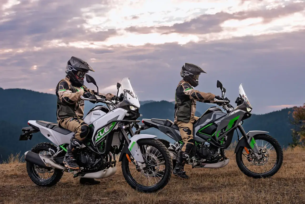 Zwei Fahrer auf Kawasaki KLE 500 Motorrädern stehen auf einem Hügel, bereit für ein Abenteuer.
