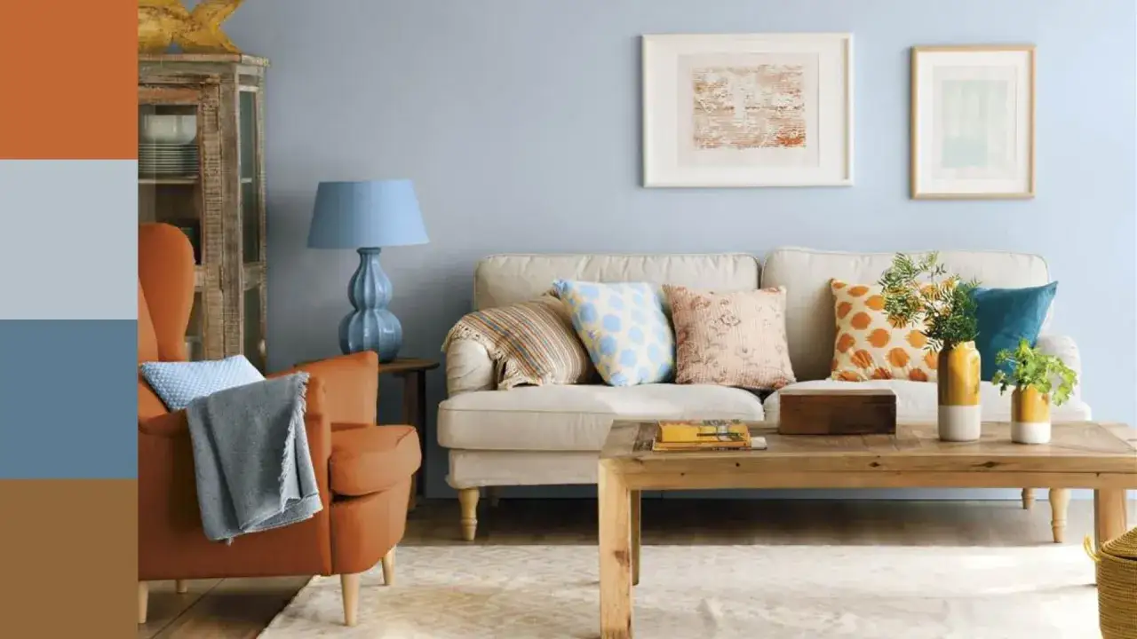 Un salón acogedor con sofá beige, sillón naranja y cojines de vivos colores. La paleta de colores salon evoca calidez y serenidad.