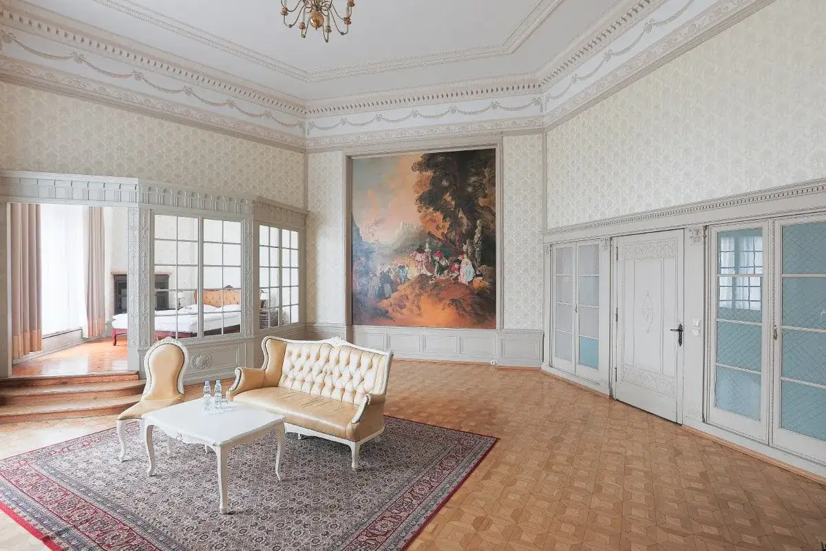 Elegancki salon z obrazem i widokiem na sypialnię. Wnętrze w stylu klasycznym, idealne na zwiedzanie **Moszna atrakcje**.