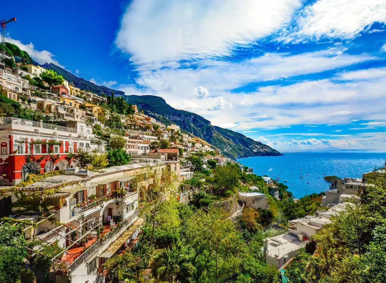 Positano, Italia: un sogno dove andare in vacanza. Case colorate aggrappate alla scogliera, mare blu intenso e cielo terso.
