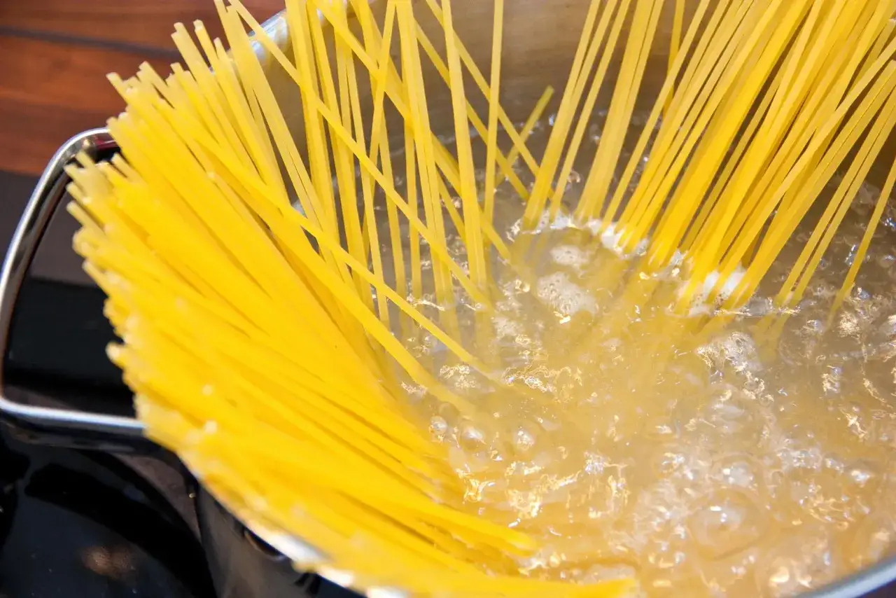 Spaghetti kochen: Ein Blick auf die 10 häufigsten Fehler beim Pasta-Kochen. Hier werden die Nudeln gerade in kochendes Wasser gegeben.