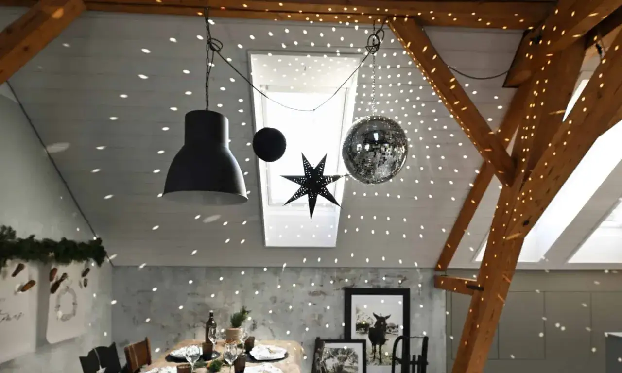 Une boule disco et une &eacute;toile d&eacute;corent le plafond, projetant des lumi&egrave;res scintillantes. Une excellente idee deco plafond noel pour une ambiance festive.