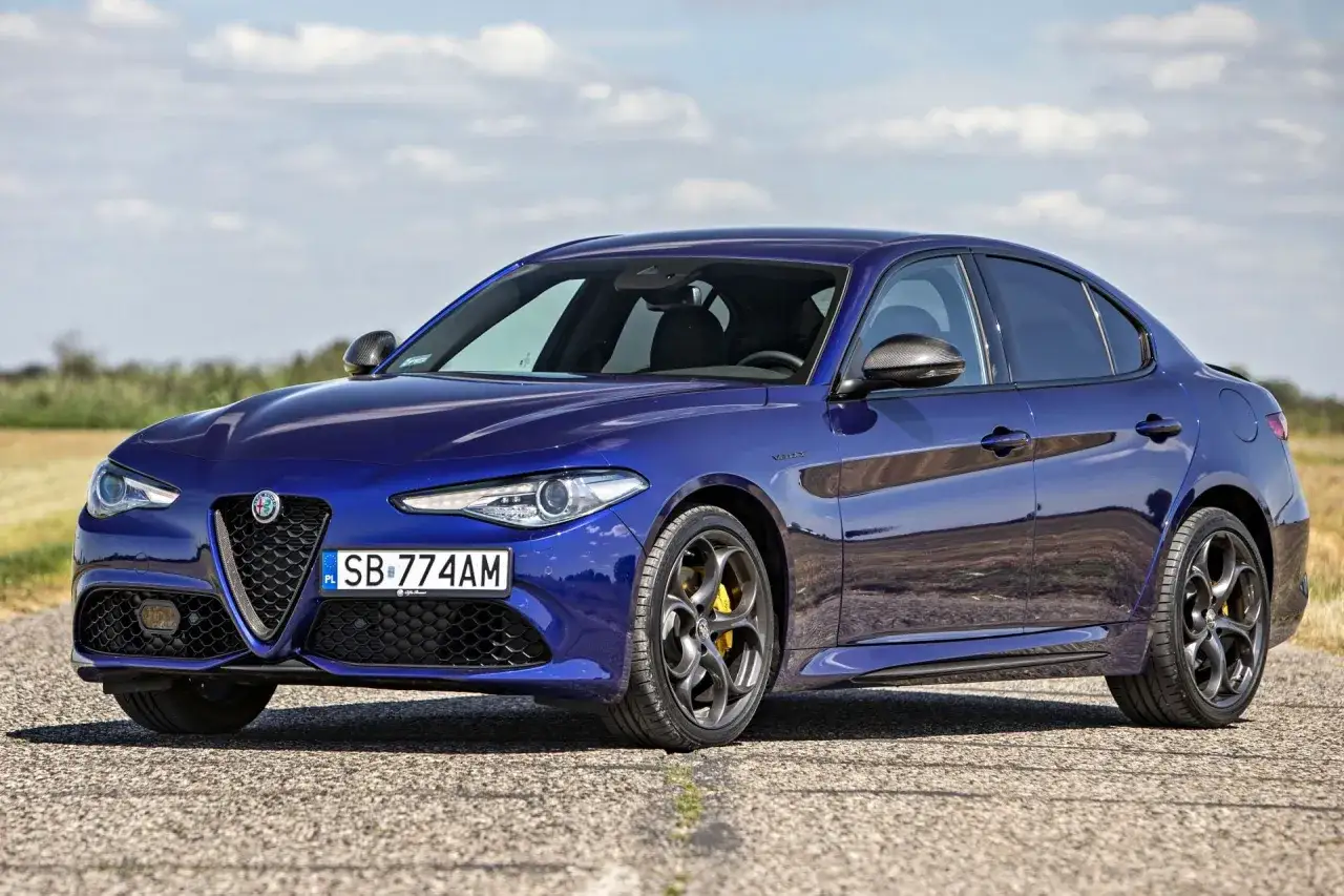 Niebieskie Alfa Romeo Giulia na drodze. Szczegółowe alfa romeo giulia dane techniczne można znaleźć w internecie.