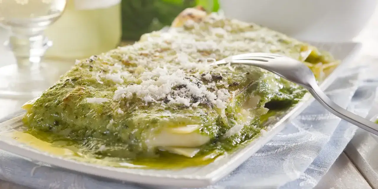 En krämig pesto lasagne med rikligt med parmesanost, redo att avnjutas.