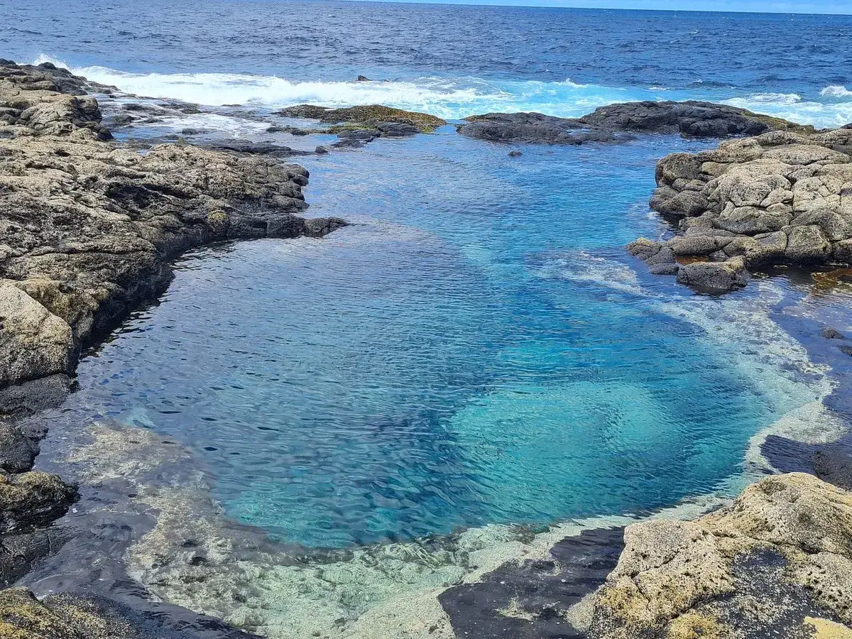 Charcones naturales de Lanzarote, piscinas de agua cristalina entre rocas volcánicas y el azul intenso del océano Atlántico.